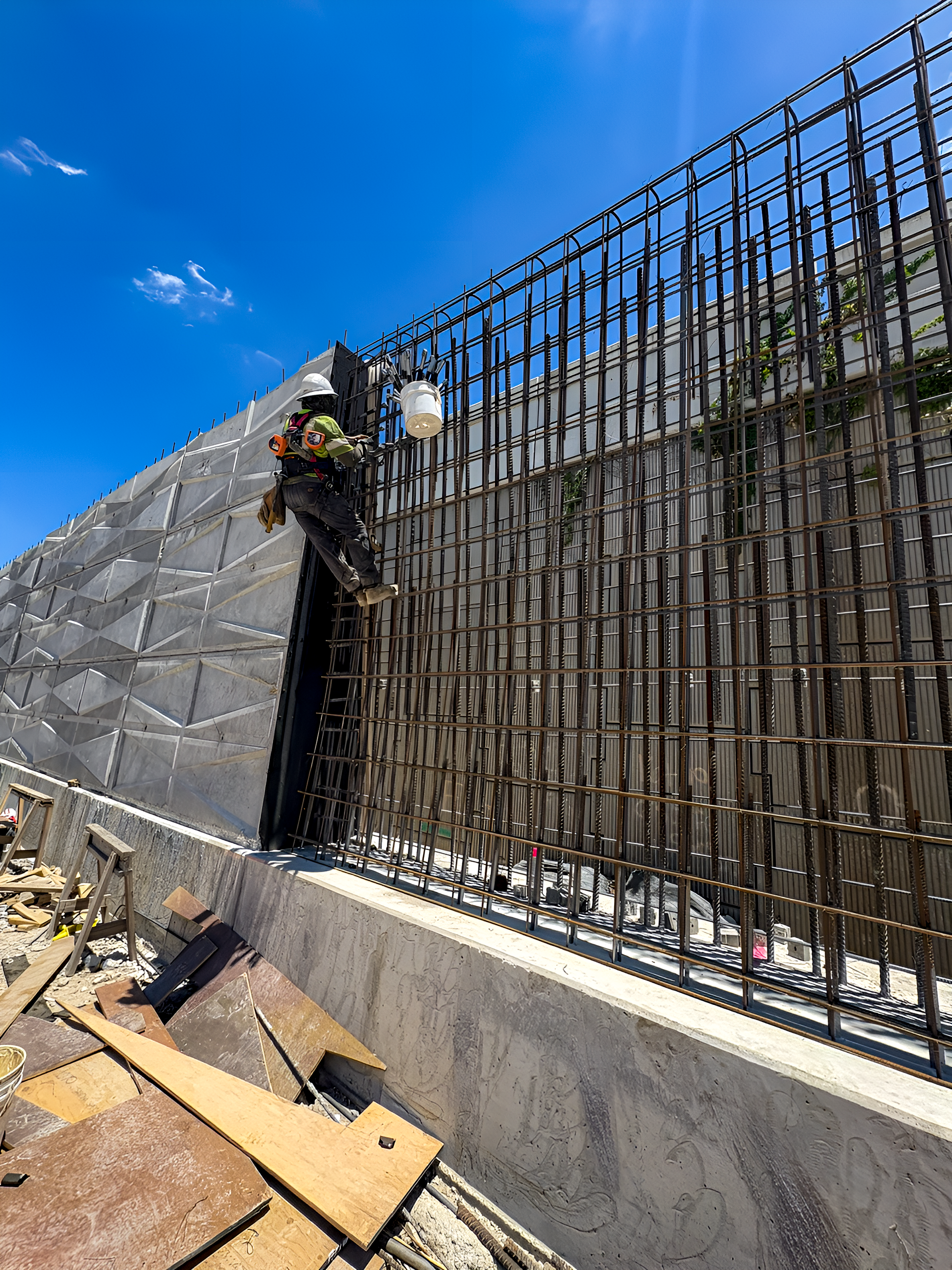 Wide shot of construction worker on wall installing the steel rebar 